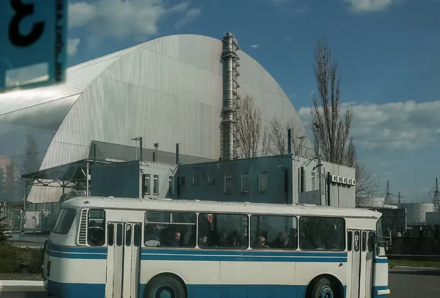 A bus carrying workers leaves in front of a new Safe Confinement (NSC) structure over the old sarcophagus covering the damaged fourth reactor at the Chernobyl nuclear power plant in Chernobyl, Ukraine April 20, 2018. (Photo by Gleb Garanich/Reuters)