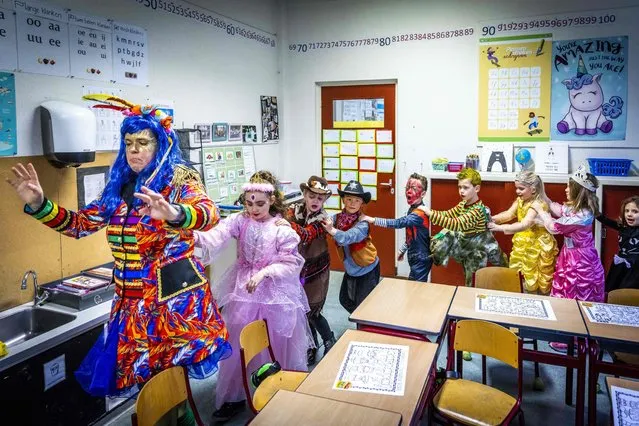 A teacher and pupils celebrate carnival at a school in Heerlen, Netherlands on February 25, 2022. (Photo by Marcel van Hoorn/ANP via AFP Photo)
