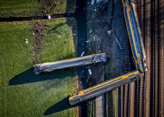 This aerial view shows a derailed night train in Voorschoten on April 4, 2023. At least one person died and 30 were injured early on April 4 when a high-speed passenger train slammed into heavy construction equipment and derailed near The Hague, Dutch emergency services said. (Photo by Remko de Waal/ANP via AFP Photo)