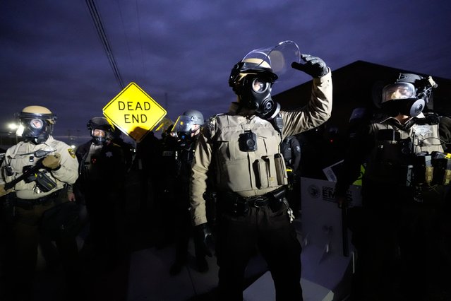 Law enforcement agents wear gas masks during a stand off with protesters outside an ICE processing facility in the Chicago suburb of Broadview, Ill., November 1, 2025. (Photo by Alex Brandon/AP Photo)