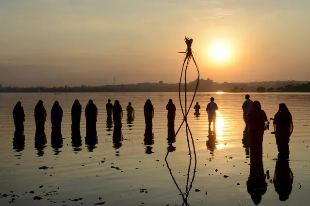 Indian Hindu devotees offer prayers to the sun during the Chhath festival on the banks of the Hussain Sagar Lake in Hyderabad on November 17, 2015. Hindu devotees pay obeisance to both the rising and the setting sun in the Chhath festival when people express their thanks and seek the blessings of the forces of nature, mainly the sun and river. (Photo by Noah Seelam/AFP Photo)