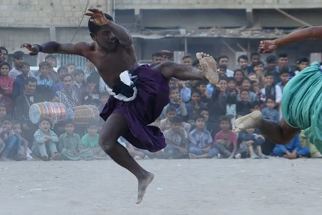 WrestlerTeddy Sheedi (L) fights his opponent during the traditional Sindhi Malakhra wrestling in Karachi, Pakistan, 13 December 2020. A Malakhra match begins with both wrestlers tying a twisted cloth around the opponent's waist. Each one then holds onto the opponent's waistcloth and tries to throw him to the ground. (Photo by Shahzaib Akber/EPA/EFE)