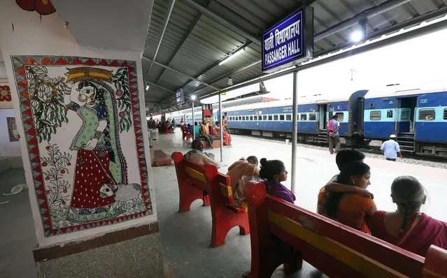 Indian passengers sit next to the Madhubani artwork at the Madhubani railway station in Bihar, India, 07 April 2018. (Photo by Harish Tyagi/EPA/EFE)