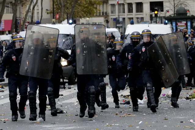 Policemen run toward activists during a protest ahead of the 2015 Paris Climate Conference, in Paris, Sunday, November 29, 2015. More than 140 world leaders are gathering around Paris for high-stakes climate talks that start Monday, and activists are holding marches and protests around the world to urge them to reach a strong agreement to slow global warming. (Photo by Christophe Ena/AP Photo)