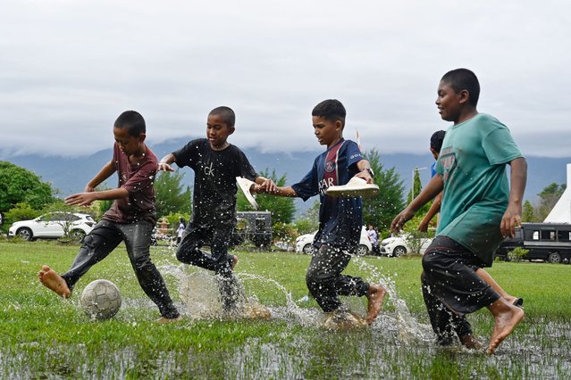 Youths play football in a flooded field following rain in Jantho, Aceh province on November 24, 2025. (Photo by Chaideer Mahyuddin/AFP Photo)