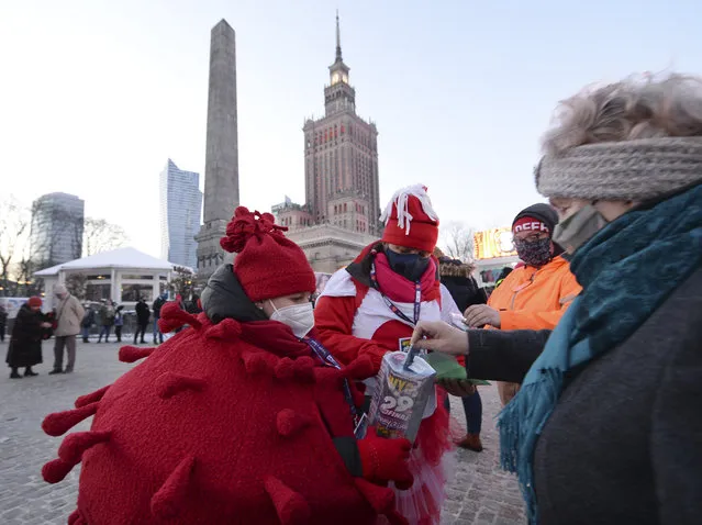 A child in a red costume collects money for Poland's most popular nationwide fundraiser for health purposes, the Great Orchestra of Christmas Charity, that was postponed by two weeks due to the pandemic, in downtown Warsaw, Poland, on Sunday, January 31, 2021. Anti-government protesters angry about a near-total abortion ban suspended their marches for the weekend to show solidarity and ensure that they didn't steal the spotlight from the event. (Photo by Czarek Sokolowski/AP Photo)