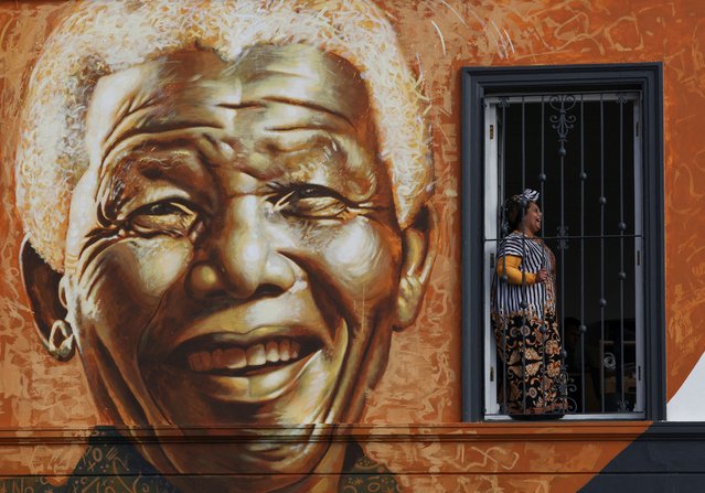 A woman reacts next to a Mandela mural painted by Stefan Smit as part of Mandela Day celebrations, which marks the birthday of anti-apartheid icon and South Africa's first democratic president, Nelson Mandela in Cape Town, South Africa, on July 18, 2025. (Photo by Esa Alexander/Reuters)