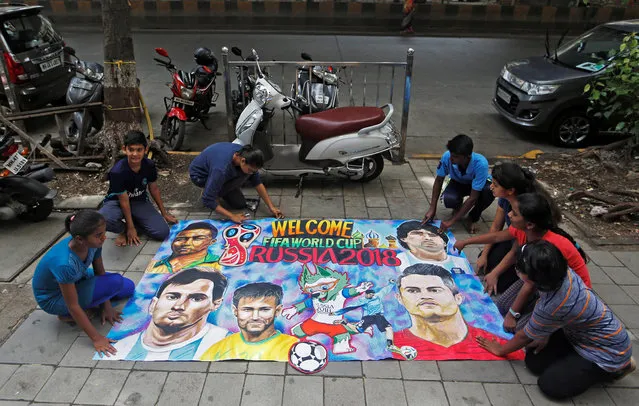 Art school students arrange a mural made for the upcoming FIFA World Cup on a street in Mumbai, India, June 13, 2018. (Photo by Francis Mascarenhas/Reuters)