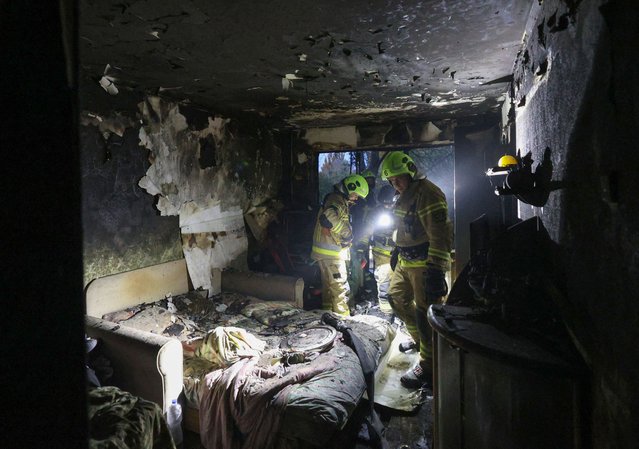 Rescuers of the State Emergency Service of Ukraine work in a multi-story building, damaged by the explosion of a drone strike in Kyiv, on October 30, 2024, amid the Russian invasion in Ukraine. Nine people, including an 11-year-old girl, were injured on October 29, 2024 in Kyiv, the capital of Ukraine, in a Russian drone attack that caused a fire in the affected building, Ukrainian authorities announced. (Photo by Anatolii Stepanov/AFP Photo)