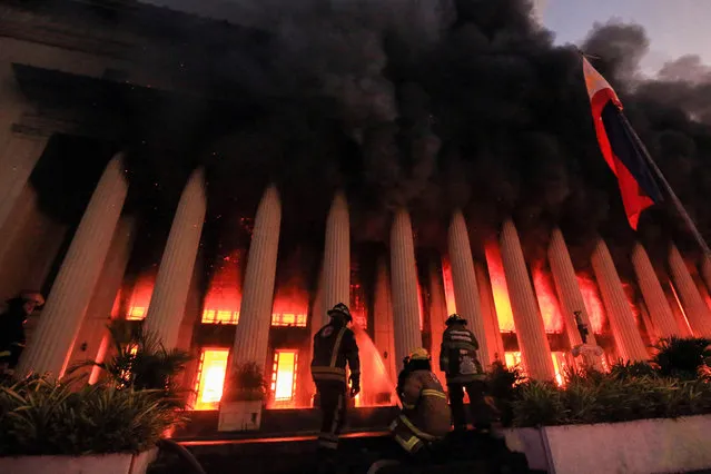 Firefighters douse a fire at the Post Office building in Manila on May 22, 2023. (Photo by AFP Photo/Stringer)