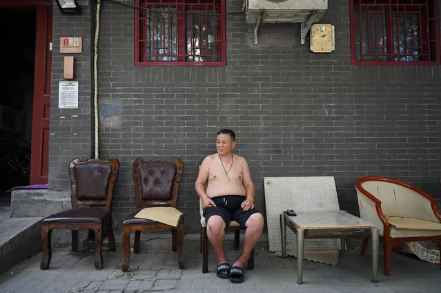 A man rests in the shade during a heatwave in Beijing on June 23, 2023. China issued its highest-level heat alert for northern parts of the country on June 23 as the capital baked in temperatures hovering around 40 degrees Celsius (104 Fahrenheit). (Photo by Greg Baker/AFP Photo)