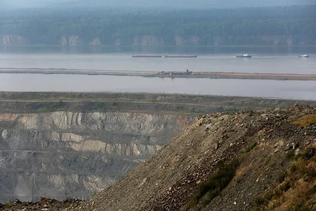 A general view shows a 180-metre-deep open-pit mine and a new dam under construction of the Gorevsky GOK lead and zinc ore mining and processing plant on a former riverbed of the Angara river near the Siberian settlement of Novoangarsk, Russia, August 16, 2016. (Photo by Ilya Naymushin/Reuters)