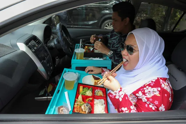 Customers dine in their car outside Padi House restaurant, during a lockdown due to the coronavirus disease (COVID-19) outbreak, in Cyberjaya, Malaysia on February 4, 2021. (Photo by Lim Huey Teng/Reuters)
