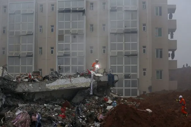Firefighters search for survivors among the debris of collapsed buildings after a landslide hit an industrial park in Shenzhen, Guangzhou, China, December 20, 2015. (Photo by Tyrone Siu/Reuters)