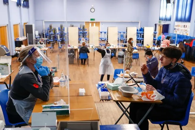 A student looks at a health worker before taking a lateral flow test at Weaverham High School, as the coronavirus disease (COVID-19) lockdown begins to ease, in Cheshire, Britain, March 9, 2021. (Photo by Jason Cairnduff/Reuters)