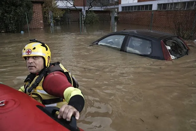 An Italian Red Cross rescuer pushes an inflatable dinghy used to evacuate people from their home in Moncalieri, near Turin, on November 25, 2016 because of the floods due to heavy rains Flooding caused by torrential rain in northern Italy was feared to have claimed at least one victim on November 25, 2016 after a man was swept away by a swollen river near Turin. Several hundreds of people had to be evacuated from their homes and many roads, schools and businesses were closed across the northwestern regions of Piedmont and Liguria as the River Po and its tributaries burst their banks in numerous places. (Photo by Marco Bertorello/AFP Photo)