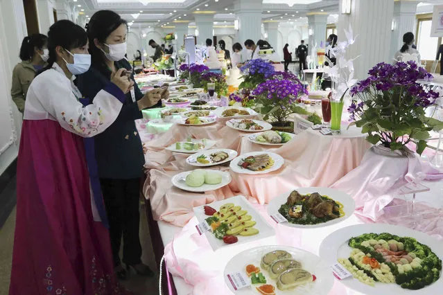 Participants look around dishes on display during the 26th Cooking Festival at the Pyongyang Noodle House in Pyongyang, North Korea, Tuesday, April 11, 2023. (Photo by Jon Chol Jin/AP Photo)
