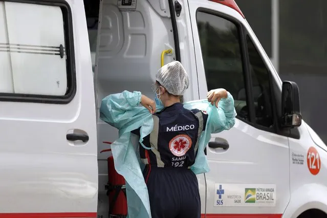 A doctor prepares to transport a patient suspected of having COVID-19 into the HRAN public hospital from an ambulance in Brasilia, Brazil, Wednesday, April 14, 2021. (Photo by Eraldo Peres/AP Photo)