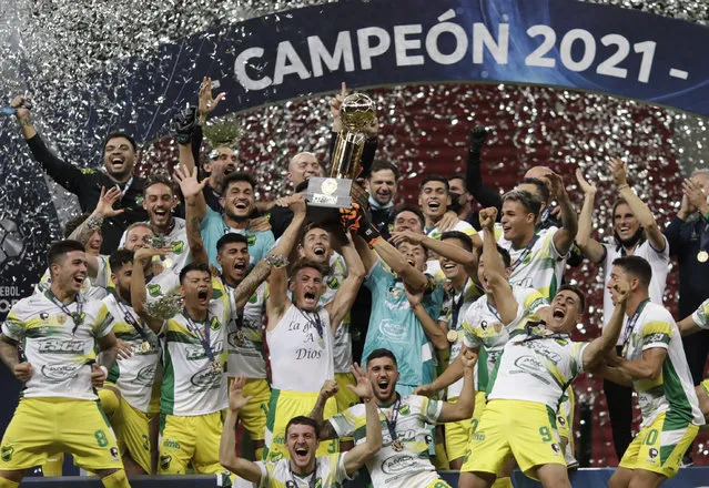 Players of Argentina's Defensa y Justicia celebrate with the trophy after winning the Recopa Sudamericana final soccer match against Brazil's Palmeiras in a penalty kick shoot-out at the Mane Garrincha stadium in Brasilia, Brazil, Wednesday, April 14, 2021. (Photo by Ueslei Marcelino/Pool via AP Photo)