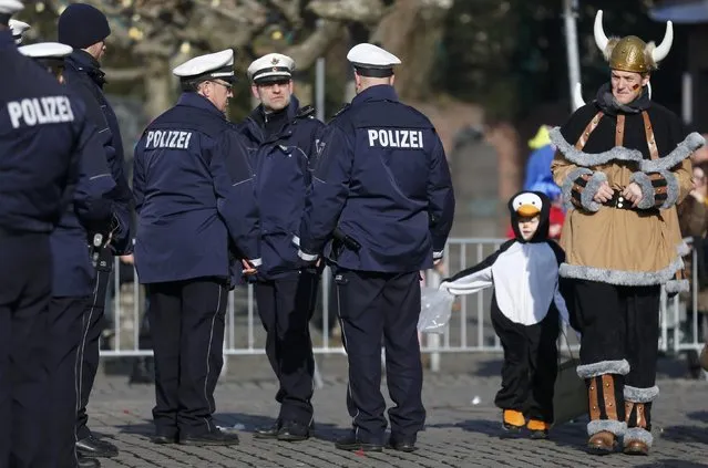 Carnival revellers walk past police during the traditional Rose Monday carnival parade in the western German city of Duesseldorf February 16, 2015. (Photo by Ina Fassbender/Reuters)