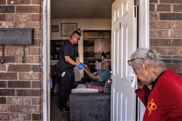 McNeese, 67, reacts as Eric Bailon, a paramedic with the Galveston County Health District, assesses her partner Jordan, 85, after medics say he overheated and fell in his kitchen during a heat wave in Galveston, Texas, U.S., August 27, 2023. (Photo by Adrees Latif/Reuters)