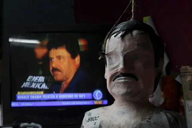 A pinata in progress depicting the drug lord Joaquin "El Chapo" Guzman is seen in front of a television showing a news bulletin of him, at a workshop in Reynosa, in Tamaulipas state, Mexico, January 13, 2016. (Photo by Daniel Becerril/Reuters)