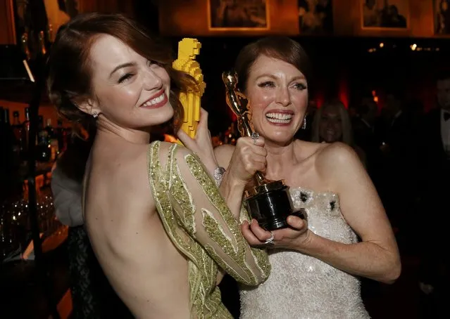 Actress Emma Stone (L) compares her Lego Oscar statuette with actress Julianne Moore's genuine Oscar for best leading actress for her role in “Still Alice” at the Governors Ball following the 87th Academy Awards in Hollywood, California February 22, 2015. (Photo by Mario Anzuoni/Reuters)