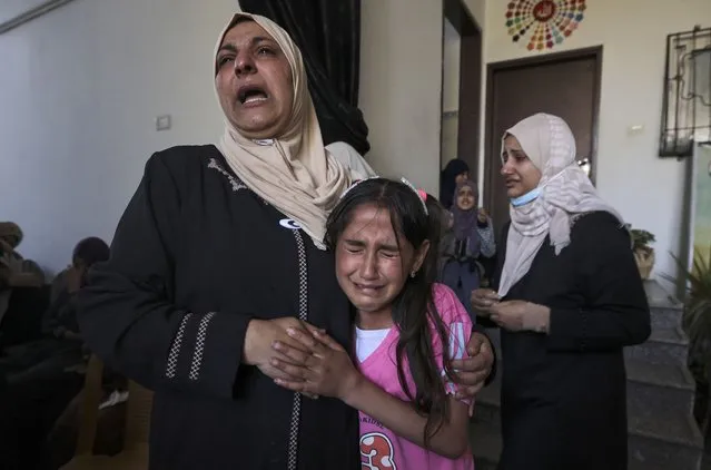The sister (R) and relatives of Palestinian Mahmoud Shtawi, 19, cry during his funeral on May 19, 2021 in Gaza City, after he was killed in an Israeli air strike. Deafening air strikes and rocket fire once more shook Gaza overnight and early today amid an international diplomatic push to broker a ceasefire after more than a week of bloodshed. (Photo by Mahmud Hams/AFP Photo)