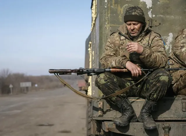 A member of the Ukrainian armed forces smokes as he sits at a military vehicle near Artemivsk, eastern Ukraine, February 23, 2015. Ukraine's military said on Monday two of its soldiers had been killed and 10 wounded in the past 24 hours, signalling that fighting has not stopped to allow a truce deal to be implemented.  REUTERS/Gleb Garanich (UKRAINE - Tags: POLITICS CIVIL UNREST MILITARY CONFLICT TPX IMAGES OF THE DAY)