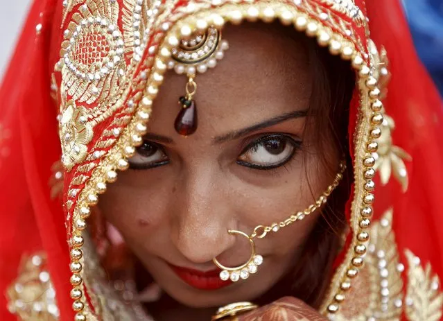 A Muslim bride watches during a mass wedding ceremony in Ahmedabad, India, January 22, 2016. (Photo by Amit Dave/Reuters)