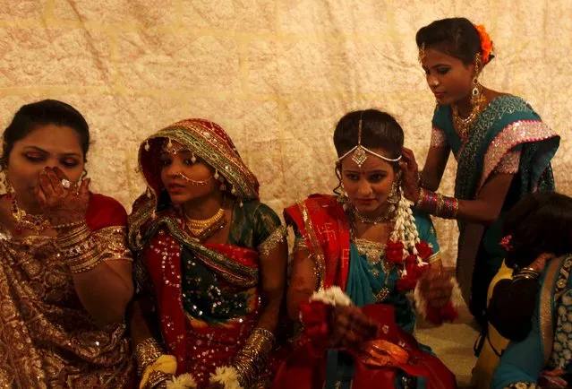 A bride and her party prepare as they wait for their wedding to start during a mass marriage ceremony in Karachi, Pakistan, January 24, 2016. The Pakistan Hindu Council organized a mass marriage ceremony where a total of 60 couples from the Hindu community residing in Pakistan's Sindh province took wedding vows, according to the council. (Photo by Akhtar Soomro/Reuters)