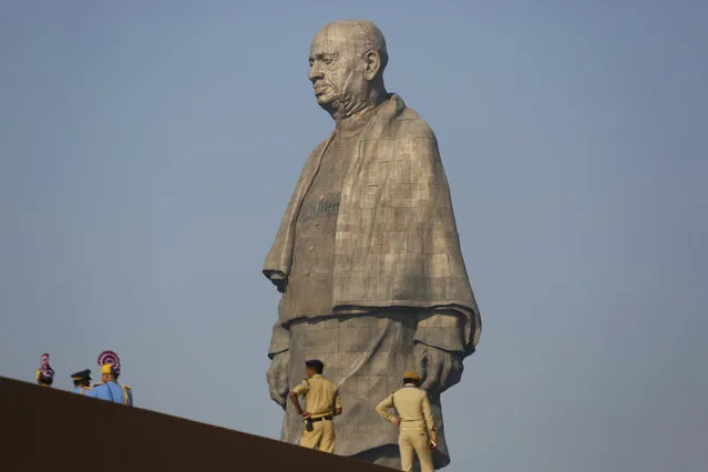 Indian policemen gather next to the Statue of Unity at Kevadiya colony in Gujarat state, India, Wednesday, October 31, 2018. The 182-meters (597 feet) bronze statue of Sardar Vallabbhai Patel, a key independence leader and the country's first home minister after British colonialists left in 1947, was inaugurated Wednesday by Indian prime minister Narendra Modi. (Photo by Ajit Solanki/AP Photo)