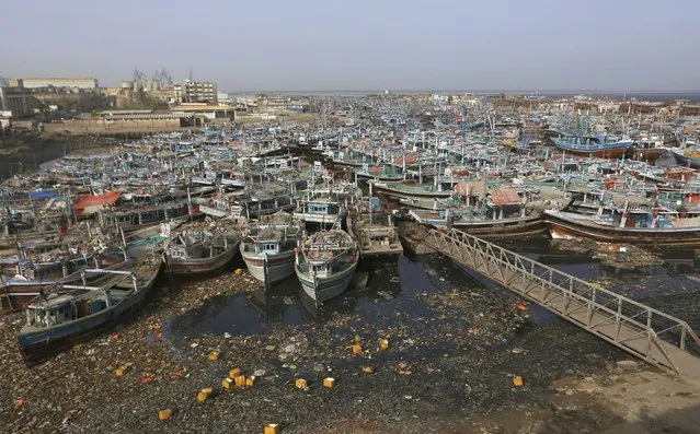 Fishing boats are anchored at a fishing harbor following authorities called back from the sea due to Cyclone Tauktae, in Karachi, Pakistan, Sunday, May 16, 2021. The meteorological department issued an alert, warning fishermen to avoid fishing in the Arabian sea in the next few days as the Cyclone Tauktae could cause rough conditions in the sea, local media reported. (Photo by Fareed Khan/AP Photo)