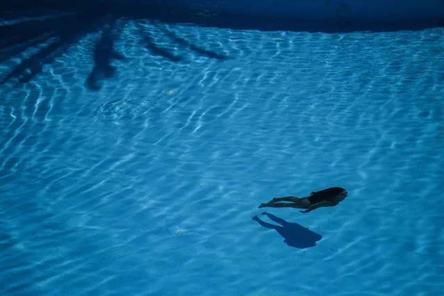 A woman dives in an hotel pool in Portimao, Algarve, south of Portugal,on May 17, 2021. British holidaymakers returned to Portugal on Monday as the country seeks to revive its battered tourism industry after lifting travel restrictions that had been imposed to curb Covid-19. (Photo by Patricia de Melo Moreira/AFP Photo)