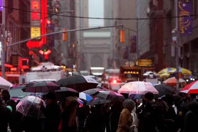 People walk through as rain falls in Times Square Manhattan, New York City, U.S., December 29, 2016. (Photo by Andrew Kelly/Reuters)