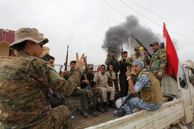 Shi'ite paramilitary fighters gesture on the back of a vehicle in Tikrit April 1, 2015. (Photo by Alaa Al-Marjani/Reuters)