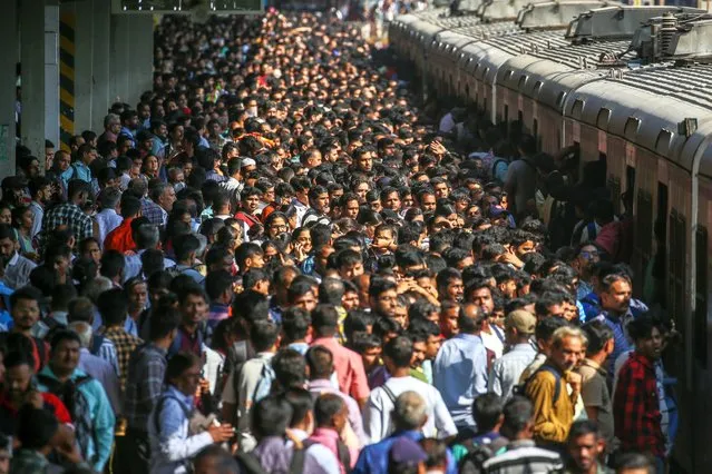 Indian commuters wait for the local train at Borivali railway station in Mumbai, India on October 27, 2023. The Western Railways canceled over 2300 suburban train services (approx. 250 trains every day) from 27 October until 05 November to complete the construction of the sixth line between Goregaon to Bandra terminus route. (Photo by Divyakant Solanki/EPA)