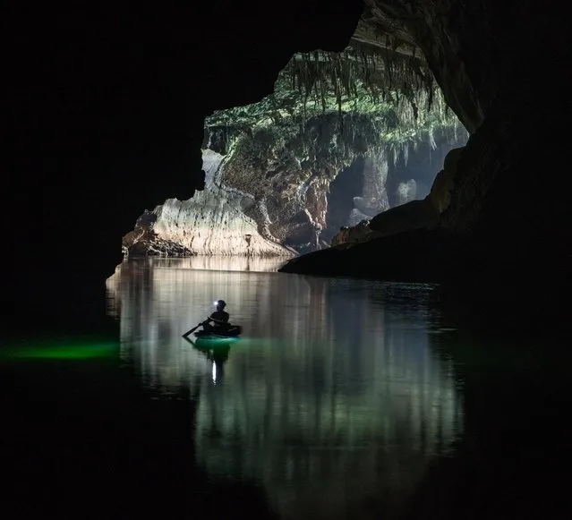 Heading into darkness, a visitor paddles a small canoe near the downstream entrance. In the dry season from November to April, the only part of the year safe to visit the cave, the water is clear and deep with a rich green hue on March 2015 at Tham Khoun Ex, Laos. (Photo by John Spies/Barcroft Media/ABACAPress)