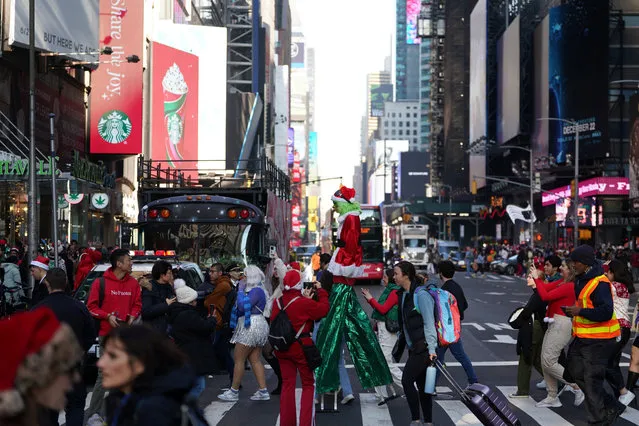 People take pictures of a person dressed as the Grinch, as revellers take part in SantaCon in New York City, New York, U.S., December 9, 2023. (Photo by David Dee Delgado/Reuters)