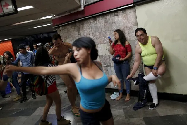 A passenger takes off his pants as others not wearing pants dance while waiting for a subway train during the “No Pants Subway Ride” in Mexico City, Mexico, February 21, 2016. (Photo by Carlos Jasso/Reuters)