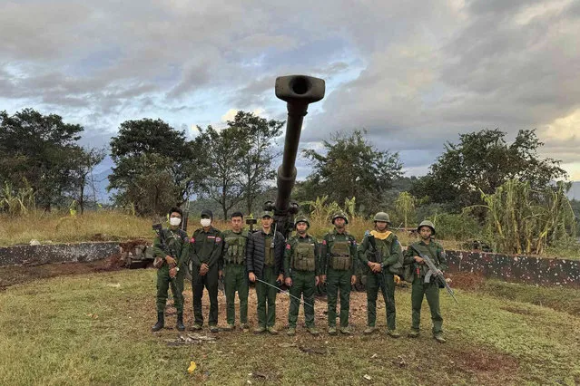 In this photo provided by the Kokang online media, members of an ethnic armed forces group, one of the three militias known as the Three Brotherhood Alliance, pose for a photograph in front of weapons the group allegedly seized from Myanmar's army outpost on a hill in Hsenwi township in Shan state, Myanmar, on November 24, 2023. A major offensive against Myanmar's military-run government by an alliance of three militias of ethnic minorities has been moving at lightning speed, inspiring resistance forces around the country to attack. (Photo by The Kokang online media via AP Photo)