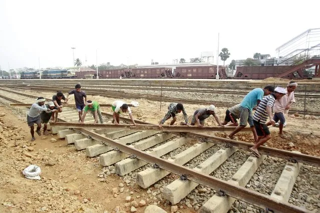 Labourers work at the installation site of a new railway track on the outskirts of Agartala, India, February 22, 2016. (Photo by Jayanta Dey/Reuters)