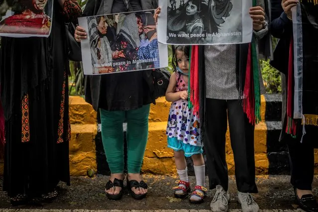 A young Afghan girls stands next to her mother participating with other Afghan women against Pakistan and the Taliban takeover of Afghanistan, in New Delhi, India, Thursday, September 16, 2021. (Photo by Altaf Qadri/AP Photo)