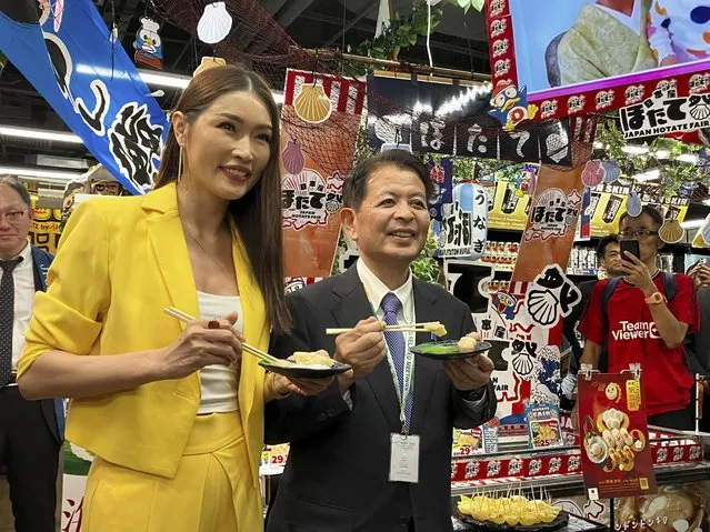 Japanese Agriculture Minister Ichiro Miyashita, right, and Malaysian celebrity Amber Chia attend an event at Japanese store, Don Don Donki in Kuala Lumpur Wednesday, October 4, 2023 to promote the safety and deliciousness of Japanese scallops to shoppers. Japan hopes to resolve the issue of China's ban on its seafood within the scope of the World Trade Organization ambit and will hold food fairs overseas to bolster seafood exports amid safety concerns over the release of treated water from the Fukushima Daiichi nuclear plant, Miyashita said Wednesday. (Photo by Eileen Ng/AP Photo)