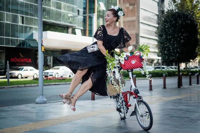A woman dismounts from her bicycle during the women themed World Car Free Day in Izmir, Turkey on September 19, 2021. The event was held to draw attention to the World Car Free Day Fancy Women Bike Ride. (Photo by Uygar Ozel/ZUMA Press Wire/Rex Features/Shutterstock)