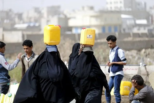 Women carry jerrycans they filled with water from a public tap amid an acute shortage of water supply to houses in Sanaa April 26, 2015. (Photo by Khaled Abdullah/Reuters)