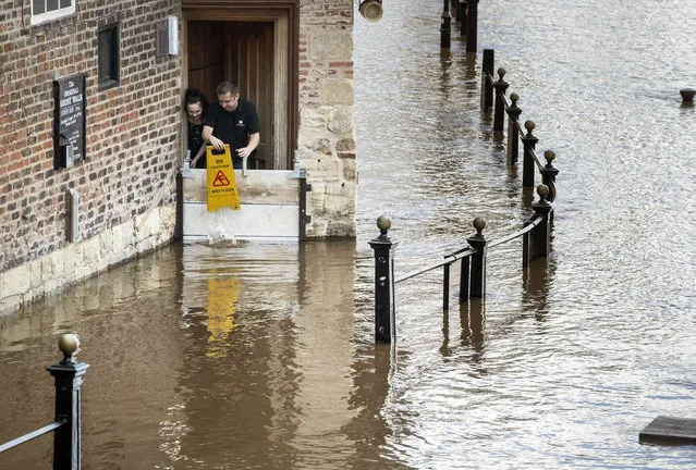 Staff at the Kings Arms look on as flood water rises after the River Ouse burst its banks, as flood warnings remained in place across the UK, in York, England, Sunday March 17, 2019. (Photo by Danny Lawson/PA Wire Press Association via AP Photo)