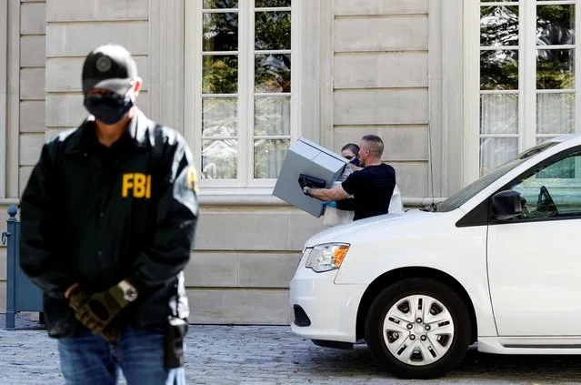 FBI agents carry items as an agent stands watch during the U.S. law enforcement agency's raid at Russian oligarch Oleg Deripaska's home in Washington, U.S., October 19, 2021. (Photo by Tom Brenner/Reuters)