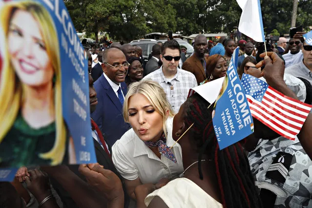 White House senior adviser Ivanka Trump is greeted by kisses as she is welcomed by local people holding U.S. flags and small flags that say “Welcome In Adzope Ivanka Trump We Love U”, in Adzope, Ivory Coast, Wednesday April 17, 2019, where she will visit Cayat, a cocoa and coffee cooperative. Trump is in Ivory Coast to promote a White House global economic program for women. (Photo by Jacquelyn Martin/AP Photo)
