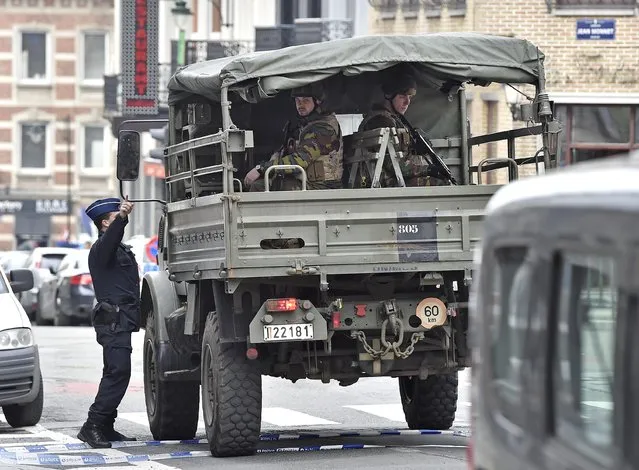 Police and military secure the city center in Brussels, Belgium, Tuesday, March 22, 2016. Authorities locked down the Belgian capital on Tuesday after explosions rocked the Brussels airport and subway system, killing  a number of people and injuring many more. Belgium raised its terror alert to its highest level, diverting arriving planes and trains and ordering people to stay where they were. Airports across Europe tightened security. (Photo by Martin Meissner/AP Photo)